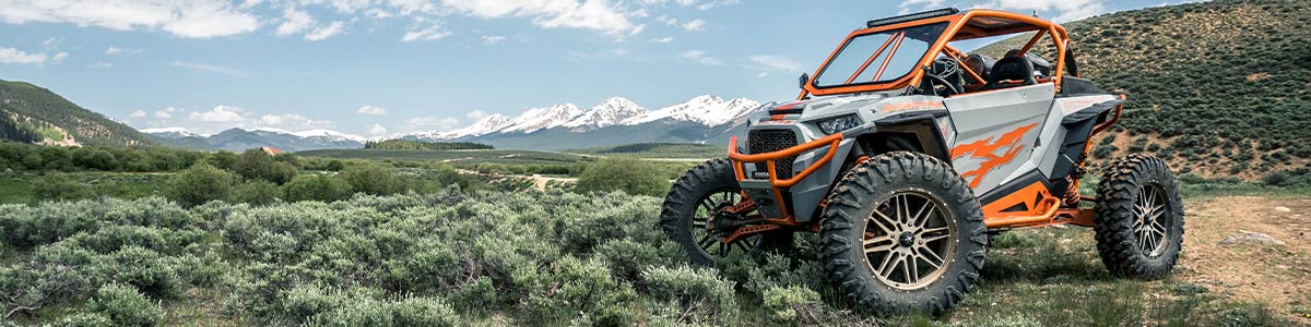 side image of an orange and gray UTV in a desert